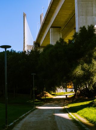 Framed Echoes: Under the bridge park, Lisbon, Portugal.

One thing that I really enjoyed about Lisbon was that the city makes use out of every piece of space they have, nothing is wasted.

I decided to go near the Vasco da Gama bridge to take some photos and to my surprise the land under the bridge is used so effectively. You've got walking paths, a skate part with a great view and picnic areas. Caught this at the entrace of the path before going off into a mini adventure.